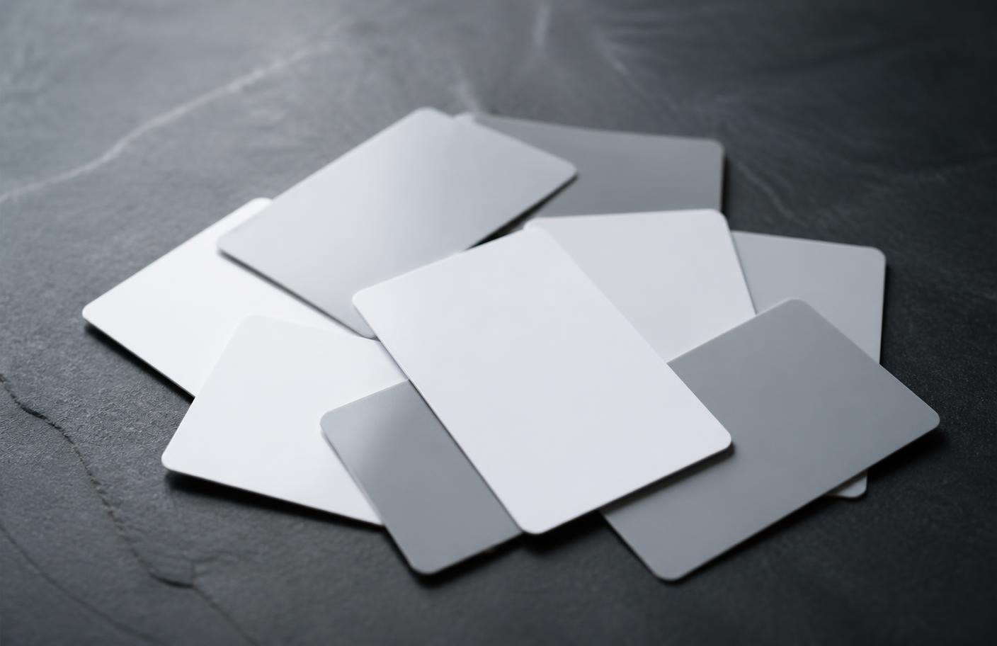 A loose stack of blank plastic keycards on a dark surface
